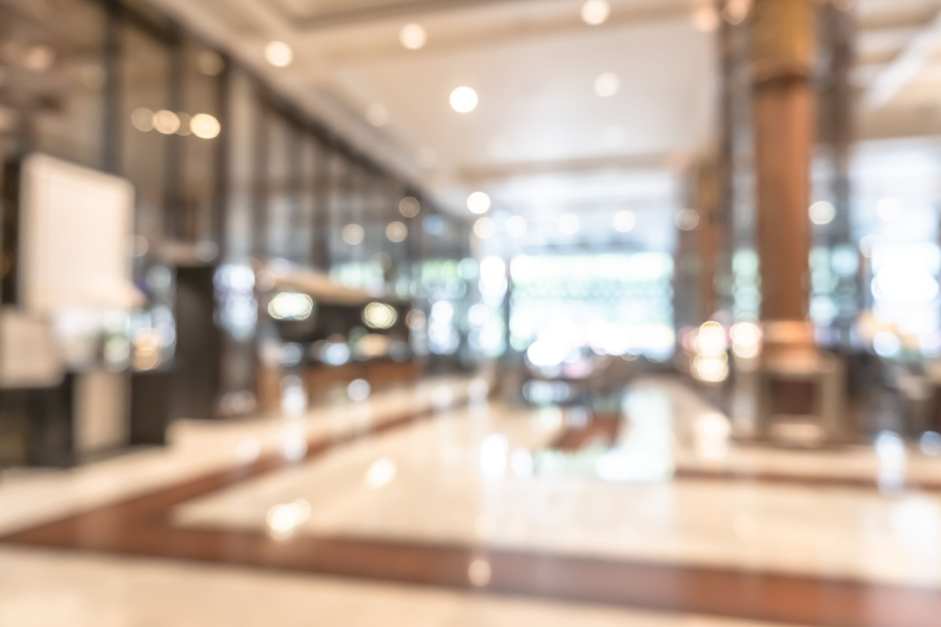 Blurred hotel or office building lobby lounge blur background interior view toward reception hall, modern luxury white room space with blurry corridor and building glass wall window